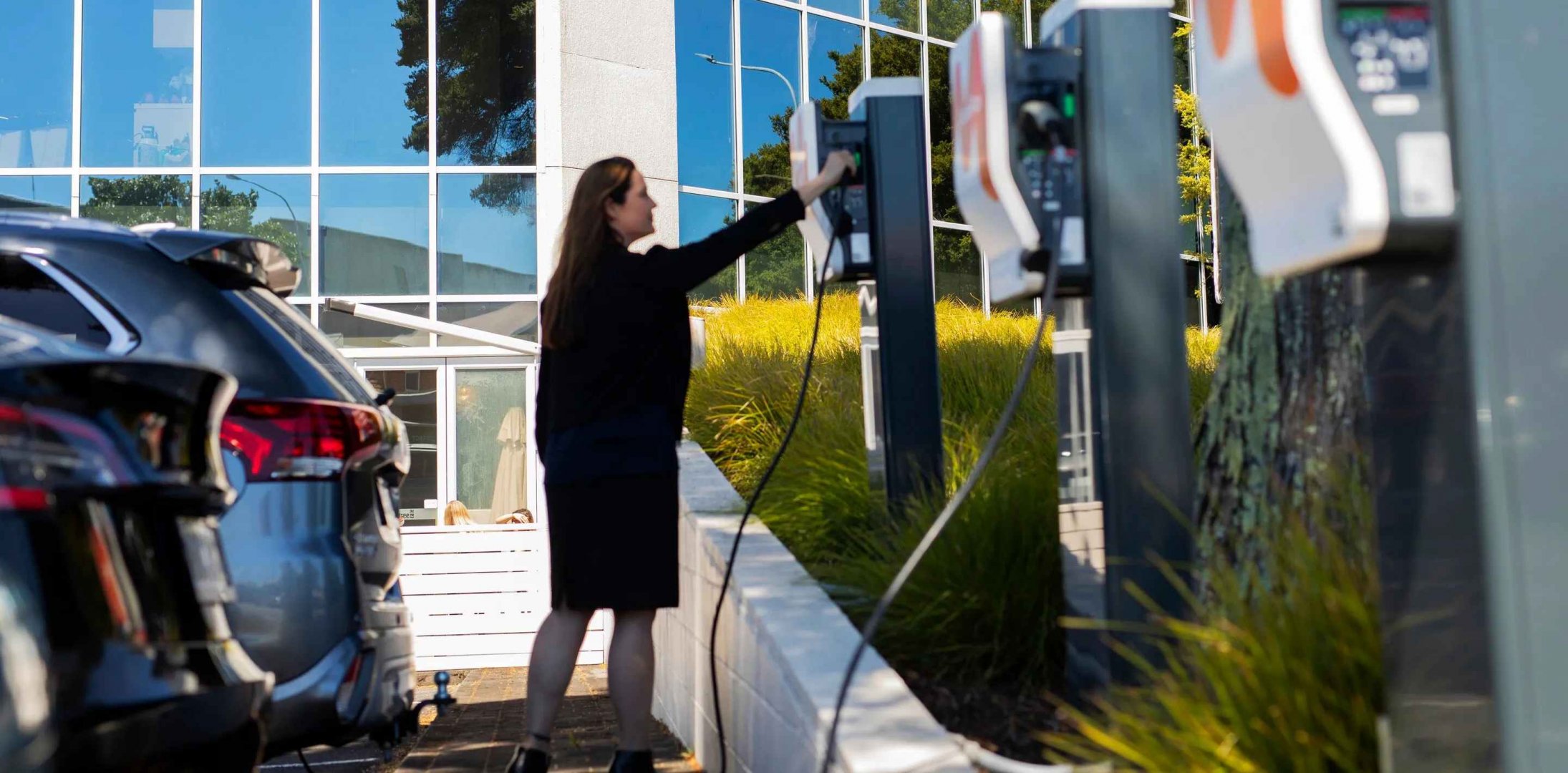 woman picking up plug from charging station.jpg